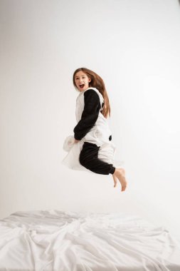 Little girl in soft warm pajama having party colored bright playing at home