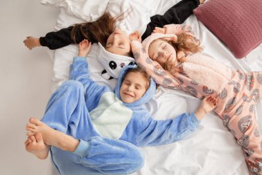 Children in soft warm pajamas having party colored bright playing at home