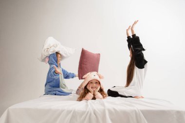 Children in soft warm pajamas having party colored bright playing at home