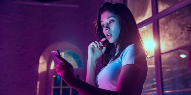 Cinematic portrait of handsome young woman in neon lighted interior clipart