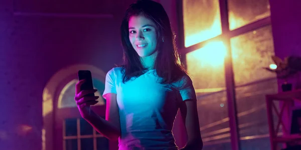 Cinematic portrait of handsome young woman in neon lighted interior — Stock Photo, Image