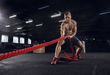 Spor salonunda egzersiz yapan sağlıklı genç bir erkek atlet.
