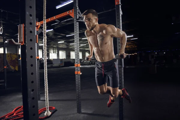 Jovem atleta masculino saudável fazendo exercícios no ginásio — Fotografia de Stock