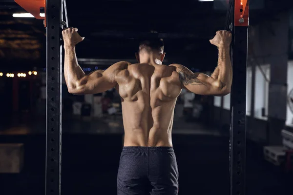 Jovem atleta masculino saudável fazendo exercícios no ginásio — Fotografia de Stock