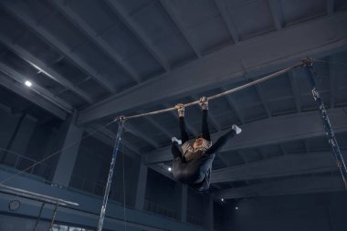 Spor salonunda küçük bir erkek jimnastikçi, esnek ve aktif.