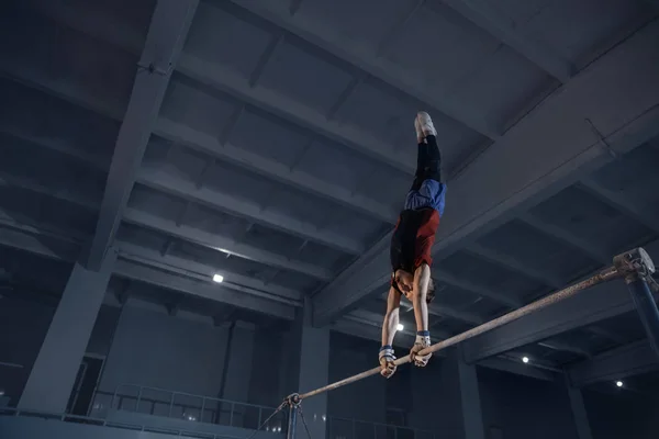 Kleine mannelijke gymnastiektraining in de sportschool, flexibel en actief — Stockfoto