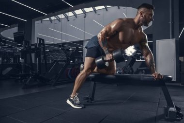 Erkek sporcu spor salonunda sıkı antrenman yapıyor. Fitness ve sağlıklı yaşam konsepti.