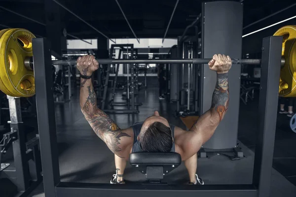 El atleta masculino entrena duro en el gimnasio. Fitness y concepto de vida saludable . —  Fotos de Stock