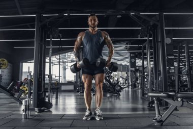Erkek sporcu spor salonunda sıkı antrenman yapıyor. Fitness ve sağlıklı yaşam konsepti.
