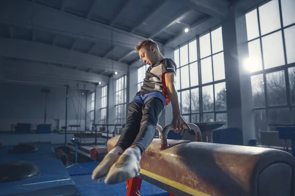 Pequeño entrenamiento de gimnasta masculino en gimnasio, flexible y activo — Foto de Stock