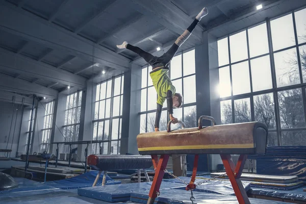 Pequeño entrenamiento de gimnasta masculino en gimnasio, flexible y activo —  Fotos de Stock