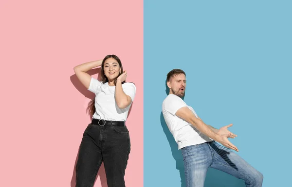 Jeune homme et femme émotionnelle sur fond rose et bleu — Photo