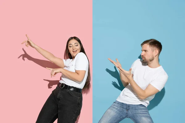 Jovem homem emocional e mulher no fundo rosa e azul — Fotografia de Stock