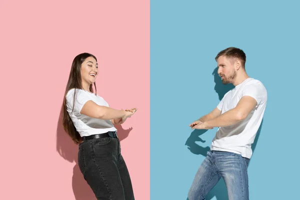 Fiatal érzelmi férfi és nő rózsaszín és kék háttér — Stock Fotó
