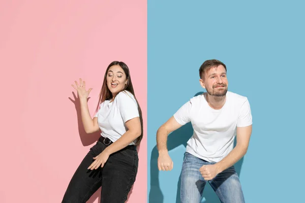 Ung emotionell man och kvinna på rosa och blå bakgrund — Stockfoto