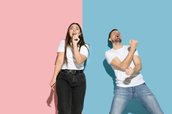 Joven hombre y mujer emocional sobre fondo rosa y azul — Foto de Stock