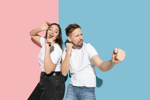 Joven hombre y mujer emocional sobre fondo rosa y azul — Foto de Stock