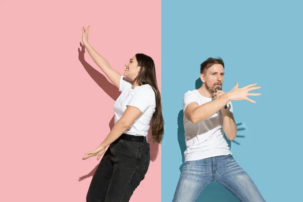 Ung emotionell man och kvinna på rosa och blå bakgrund — Stockfoto