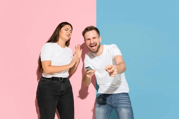 Giovane uomo e donna emotivo su sfondo rosa e blu — Foto Stock