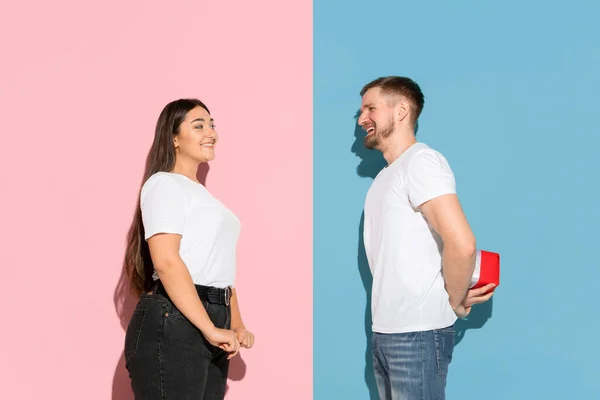 Jonge emotionele man en vrouw op roze en blauwe achtergrond — Stockfoto