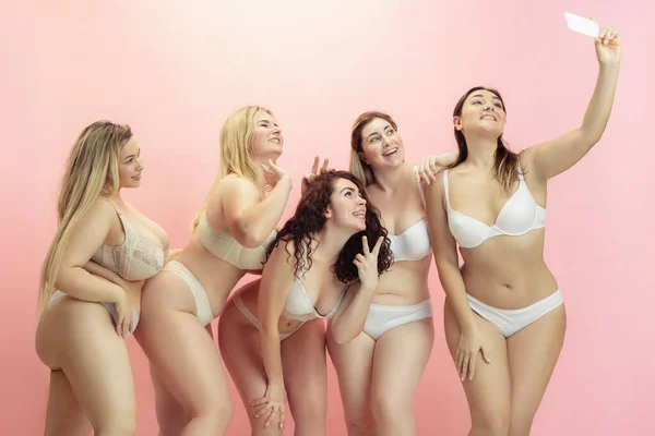 Retrato de hermosas mujeres jóvenes de tamaño grande posando sobre fondo rosa —  Fotos de Stock