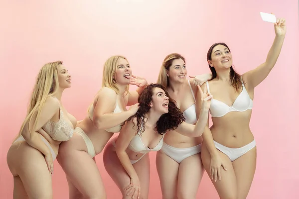 Portret van mooie plus size jonge vrouwen poseren op roze achtergrond — Stockfoto