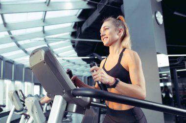 Spor salonunda sıkı çalışan bayan sporcu. Fitness ve sağlıklı yaşam konsepti.