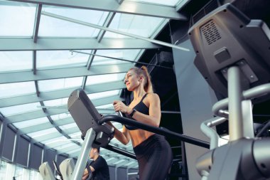 Spor salonunda sıkı çalışan bayan sporcu. Fitness ve sağlıklı yaşam konsepti.