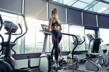 Spor salonunda sıkı çalışan bayan sporcu. Fitness ve sağlıklı yaşam konsepti.