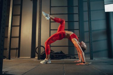 Spor salonunda sıkı çalışan bayan sporcu. Fitness ve sağlıklı yaşam konsepti.