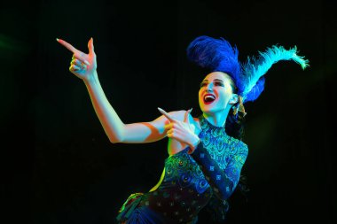 Karnaval ve maskeli balo kostümlü güzel bir kadın. Siyah arka planda renkli neon ışıklar.