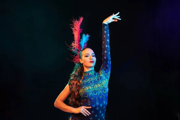 Belle jeune femme en costume de carnaval et de mascarade dans des néons colorés sur fond noir — Photo