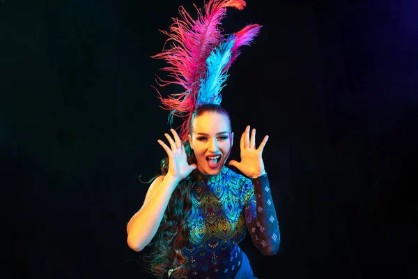 Belle jeune femme en costume de carnaval et de mascarade dans des néons colorés sur fond noir — Photo