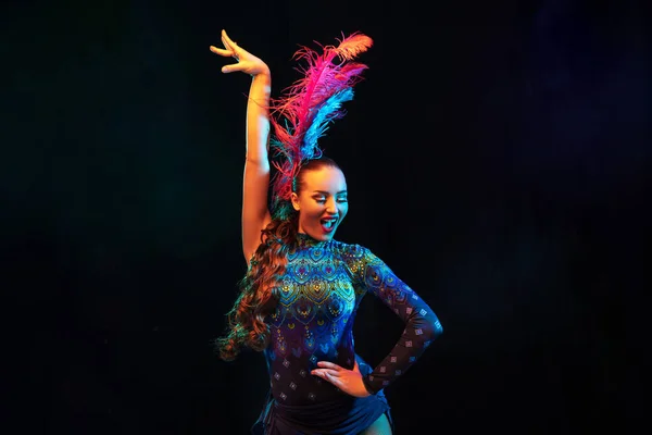 Gyönyörű fiatal nő karnevál és álarcosbál jelmez színes neon fények fekete háttér — Stock Fotó
