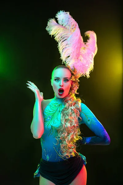 Gyönyörű fiatal nő karnevál és álarcosbál jelmez színes neon fények fekete háttér — Stock Fotó
