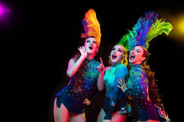 Gyönyörű fiatal nők karnevál és álarcosbál jelmez színes neon fények fekete háttér — Stock Fotó