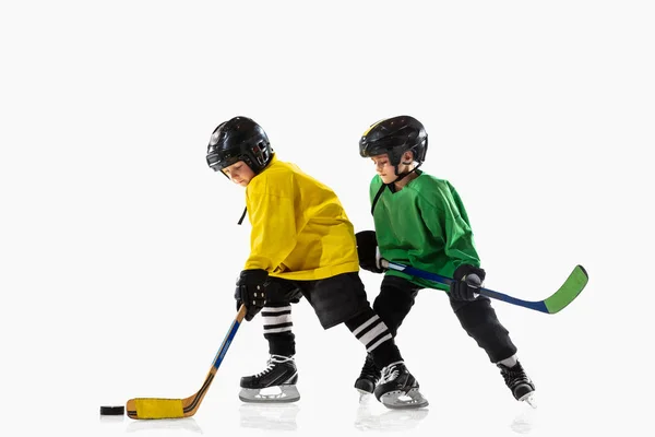 Petits joueurs de hockey avec les bâtons sur le terrain de glace et fond de studio blanc — Photo