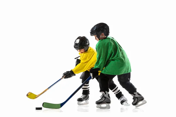 Petits joueurs de hockey avec les bâtons sur le terrain de glace et fond de studio blanc — Photo