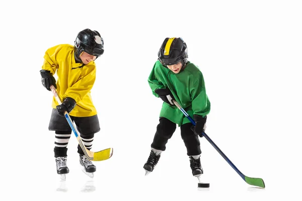 Little hokejisté s holí na ledě hřiště a bílé studio pozadí — Stock fotografie