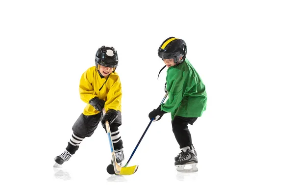 Little hockey players with the sticks on ice court and white studio background — Stock Photo, Image
