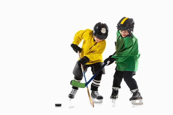 Små hockeyspelare med pinnar på isbana och vit studio bakgrund — Stockfoto