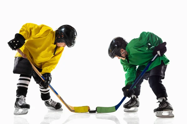 Små hockeyspelare med pinnar på isbana och vit studio bakgrund — Stockfoto