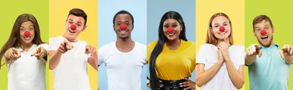 Portrét mladých lidí slaví červený nos den na barevném pozadí — Stock fotografie