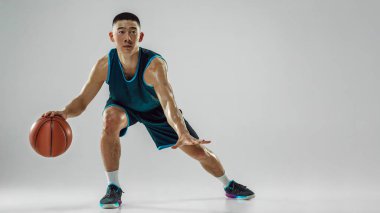 Genç basketbolcu eğitimi beyaz stüdyo arka planında izole edildi