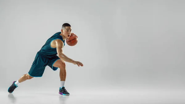 Jovem jogador de basquete treinando isolado no fundo do estúdio branco — Fotografia de Stock