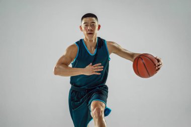 Genç basketbolcu eğitimi beyaz stüdyo arka planında izole edildi