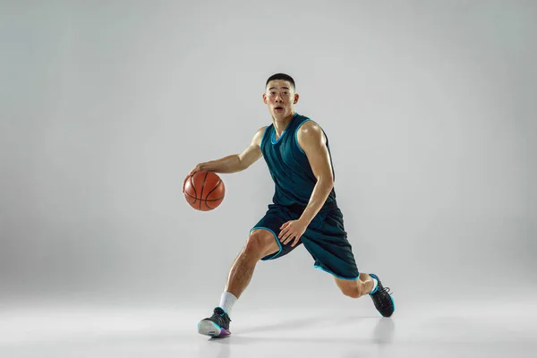 Jovem jogador de basquete treinando isolado no fundo do estúdio branco — Fotografia de Stock