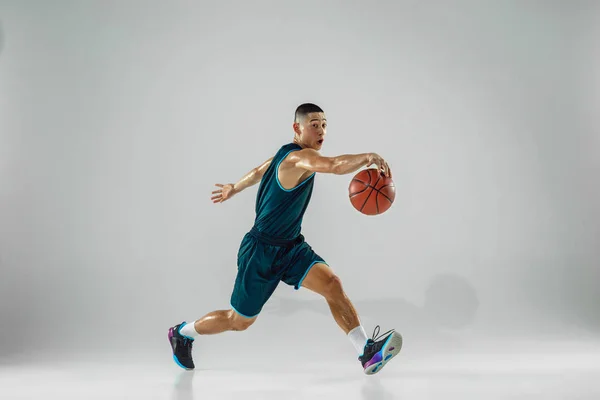 Jovem jogador de basquete treinando isolado no fundo do estúdio branco — Fotografia de Stock