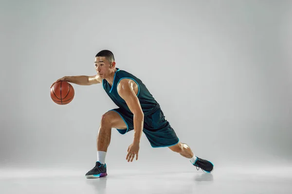 Jovem jogador de basquete treinando isolado no fundo do estúdio branco — Fotografia de Stock