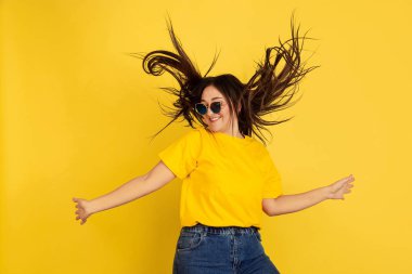 Sarı stüdyo arka planında izole edilmiş beyaz kadın portresi.